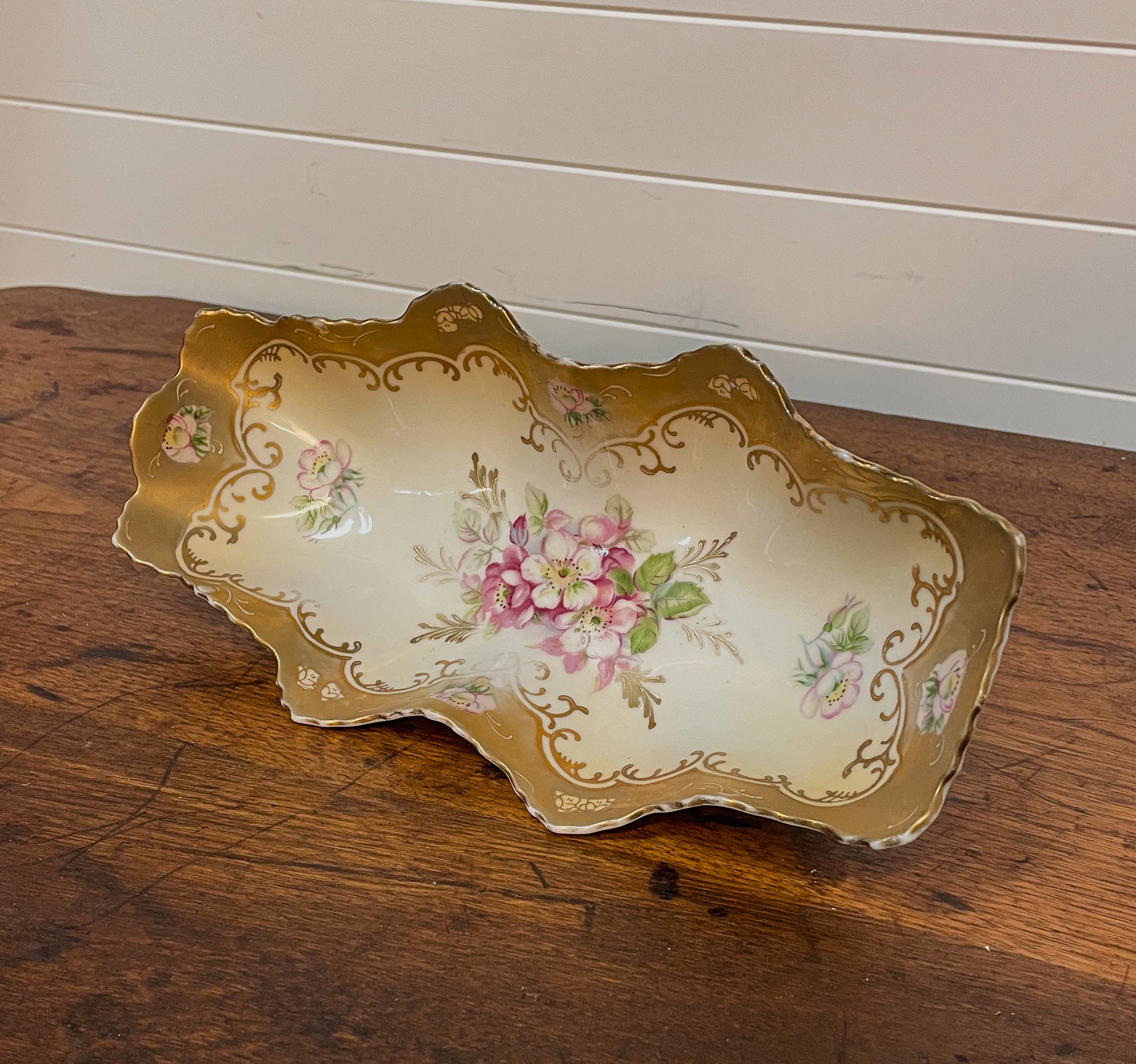 Decorative ceramic tray with floral design on a wooden surface