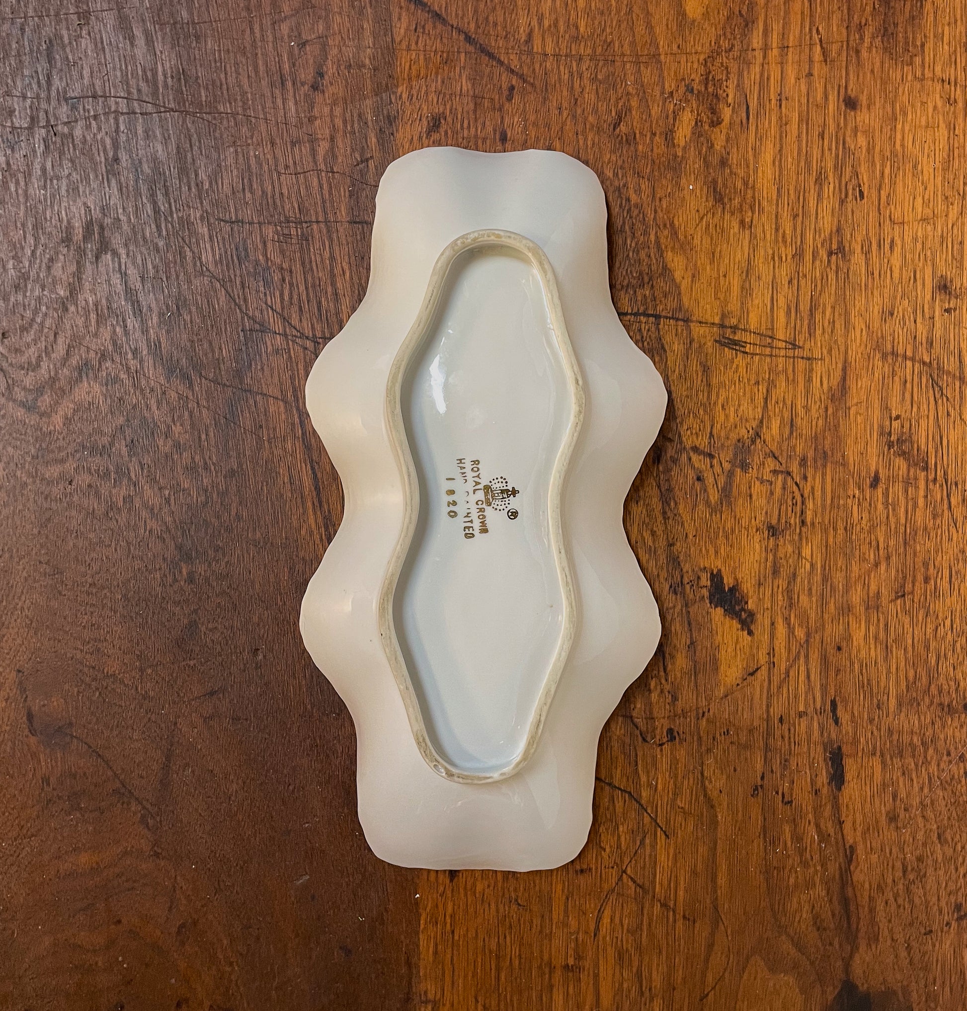 White ceramic dish with wavy edges on a wooden surface