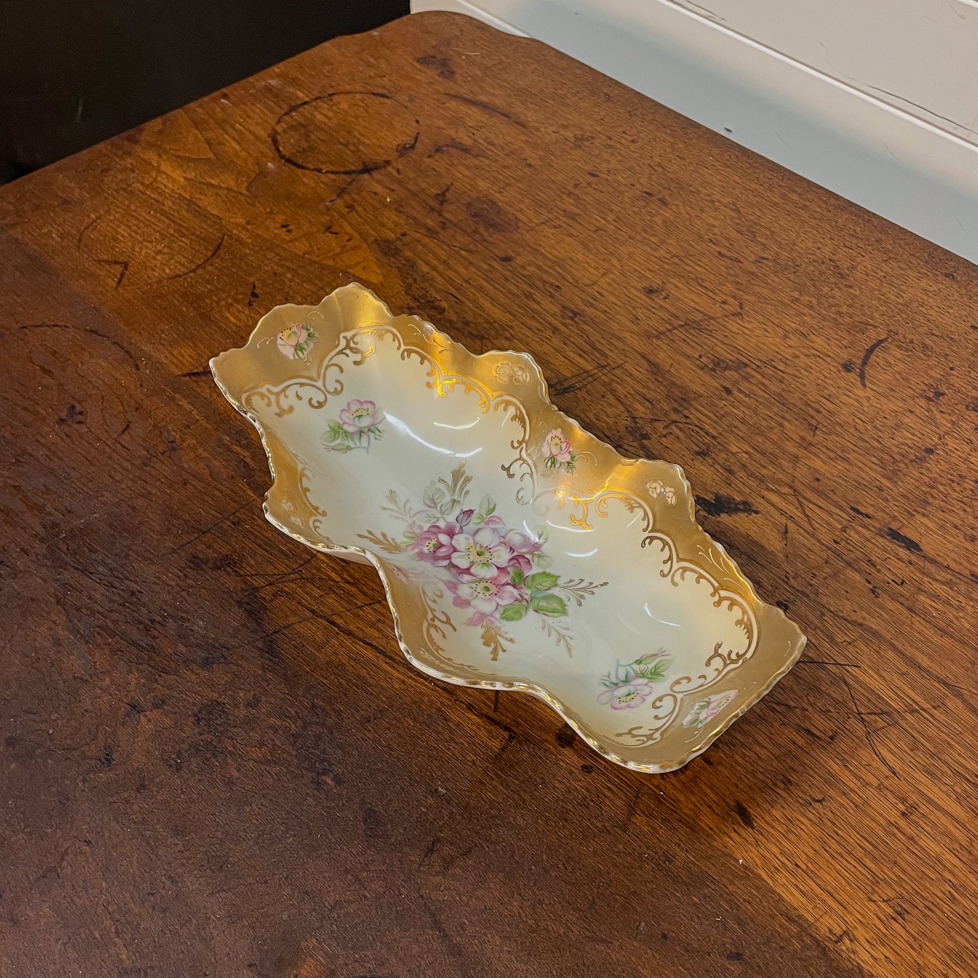 Decorative ceramic tray with floral patterns on a wooden surface