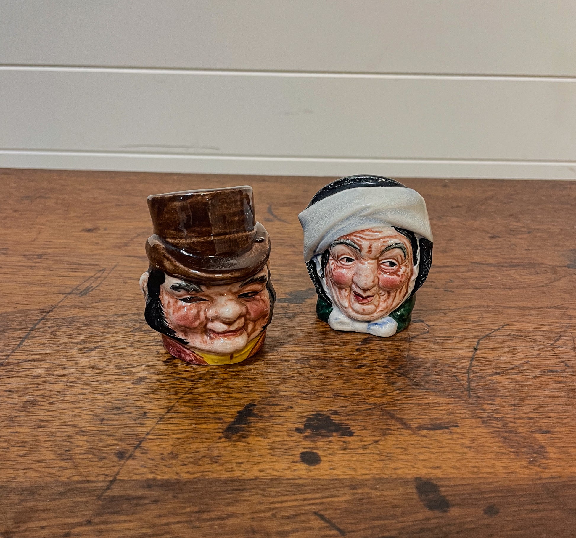 Two ceramic character heads on a wooden floor