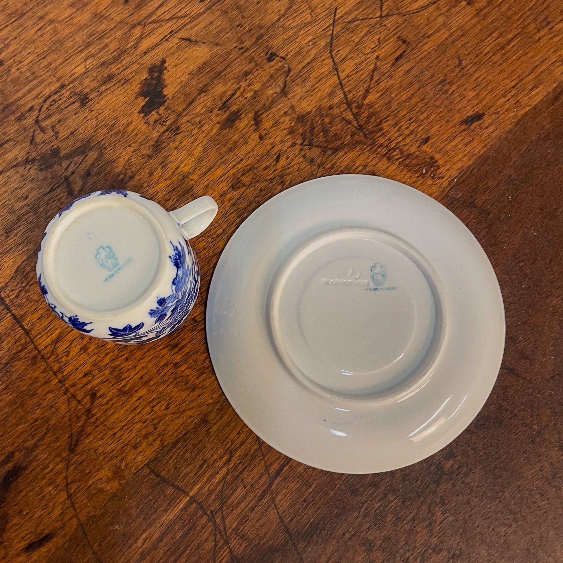 Ceramic cup and saucer with blue floral patterns on a wooden surface