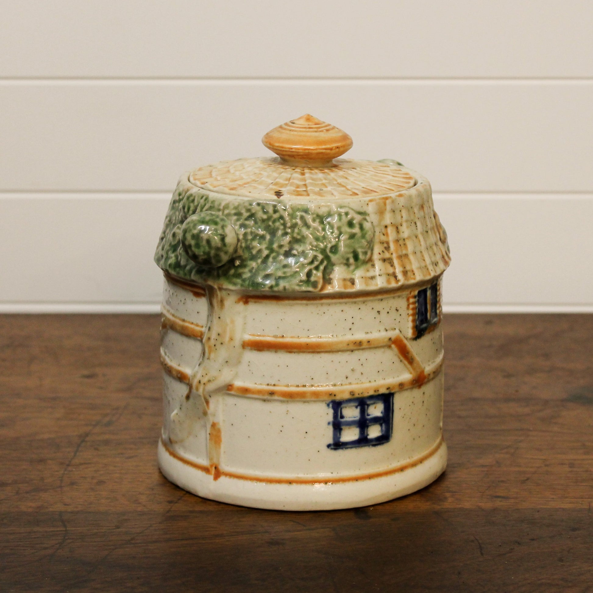 Ceramic jar with a lid on a wooden surface