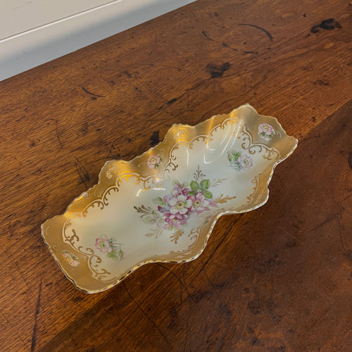 Decorative ceramic dish with floral patterns on a wooden surface