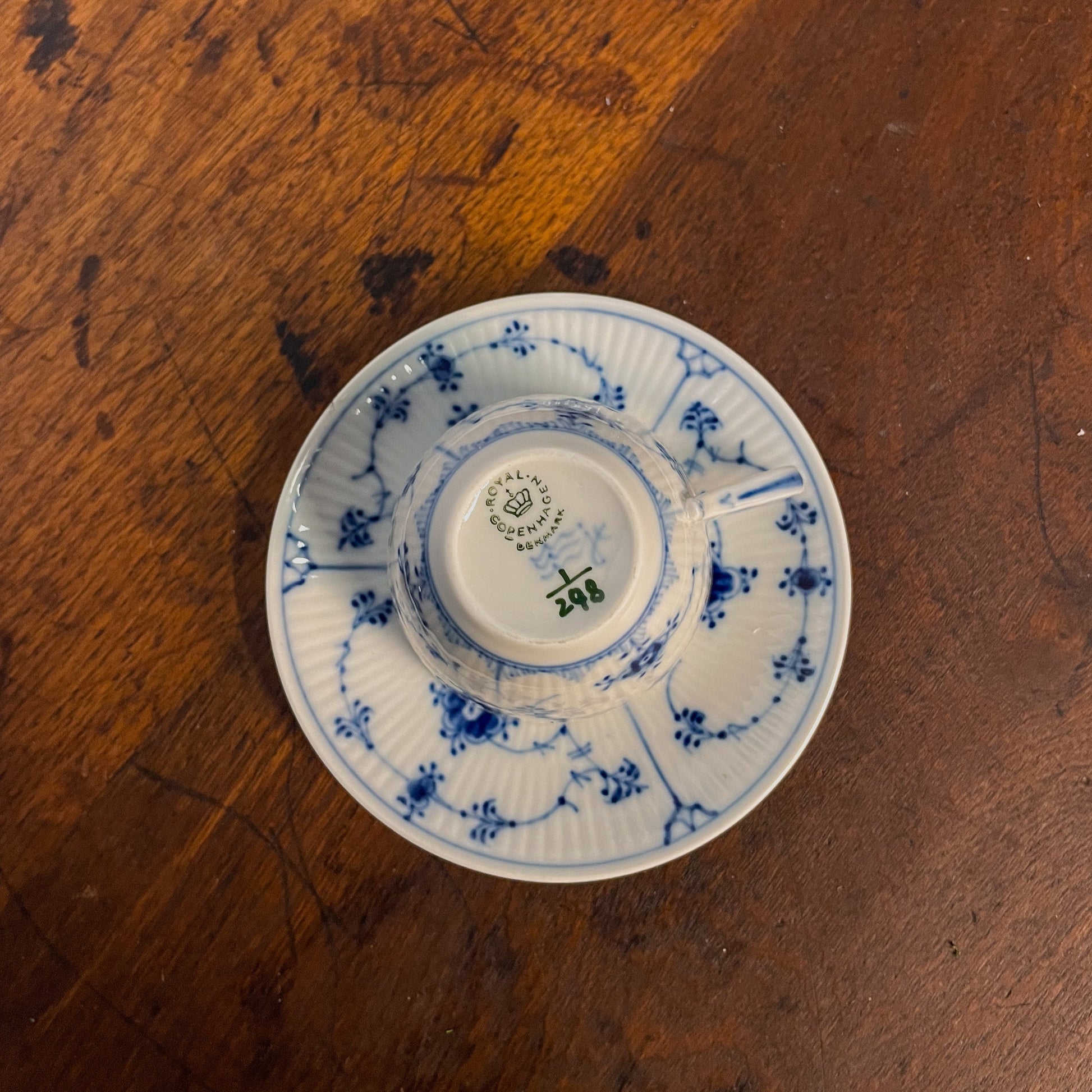 White ceramic cup with blue floral patterns on a wooden surface