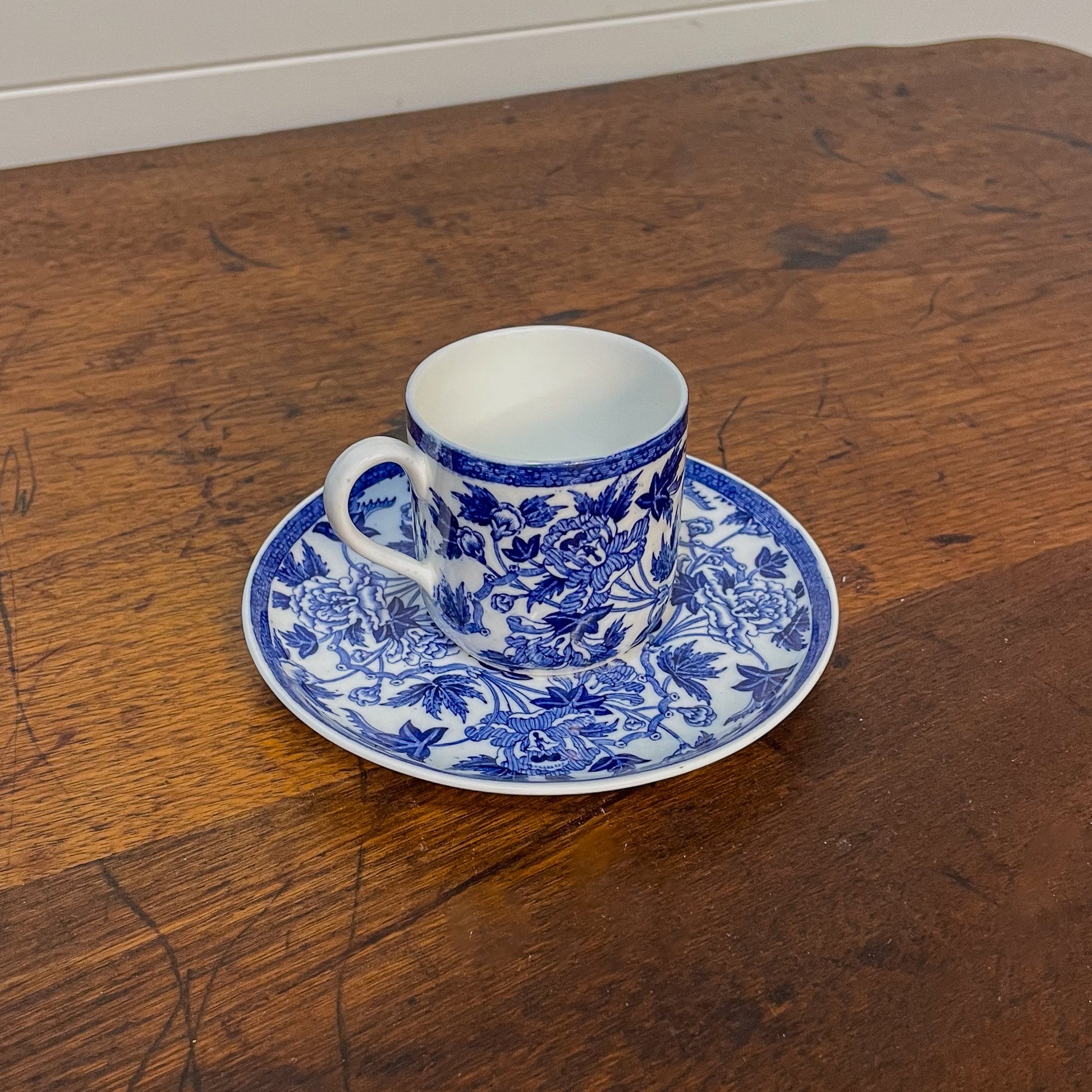 Blue and white teacup and saucer on a wooden surface