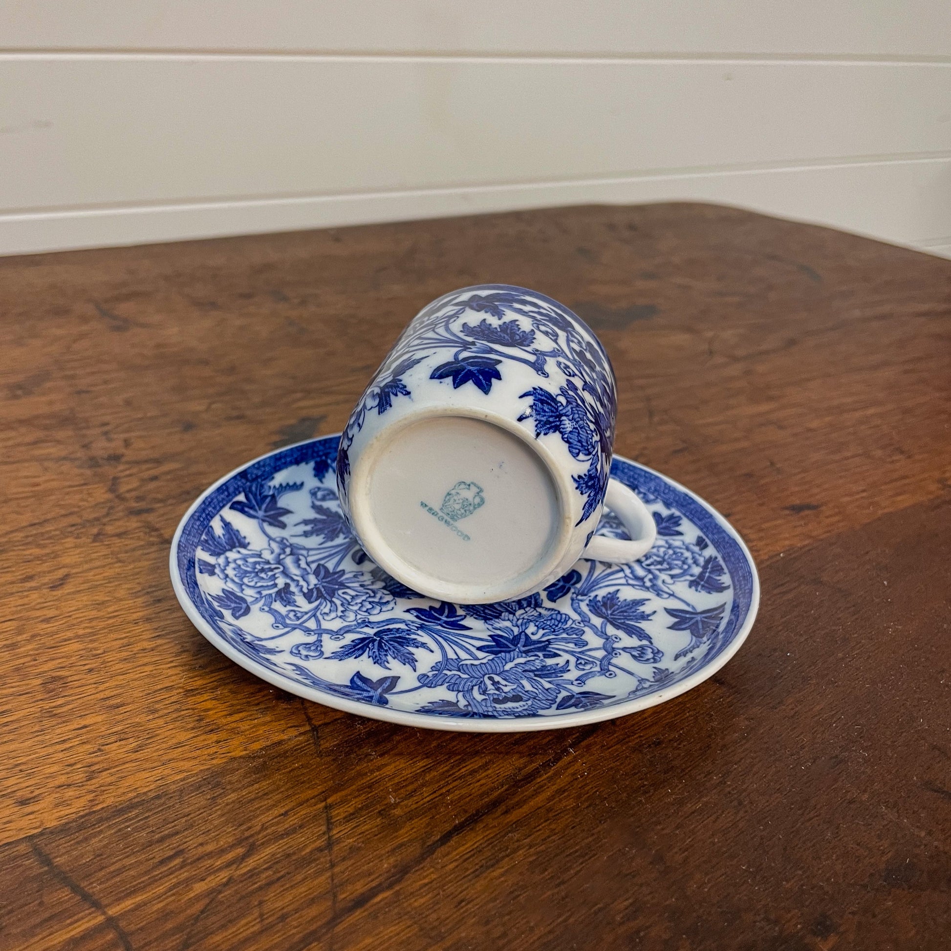 Blue and white floral teacup and saucer on a wooden surface