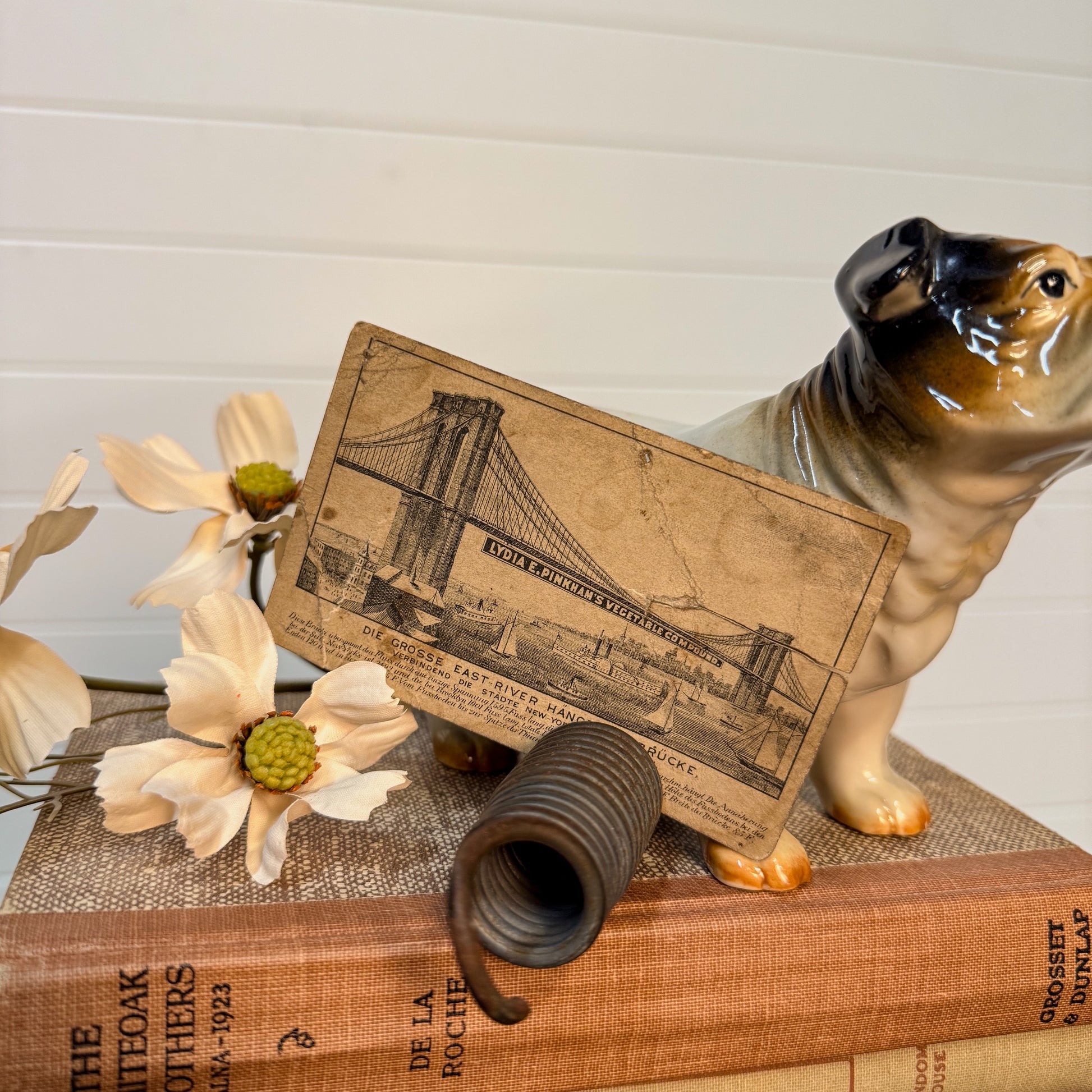 Dog figurine with a book and floral arrangement on a wooden surface