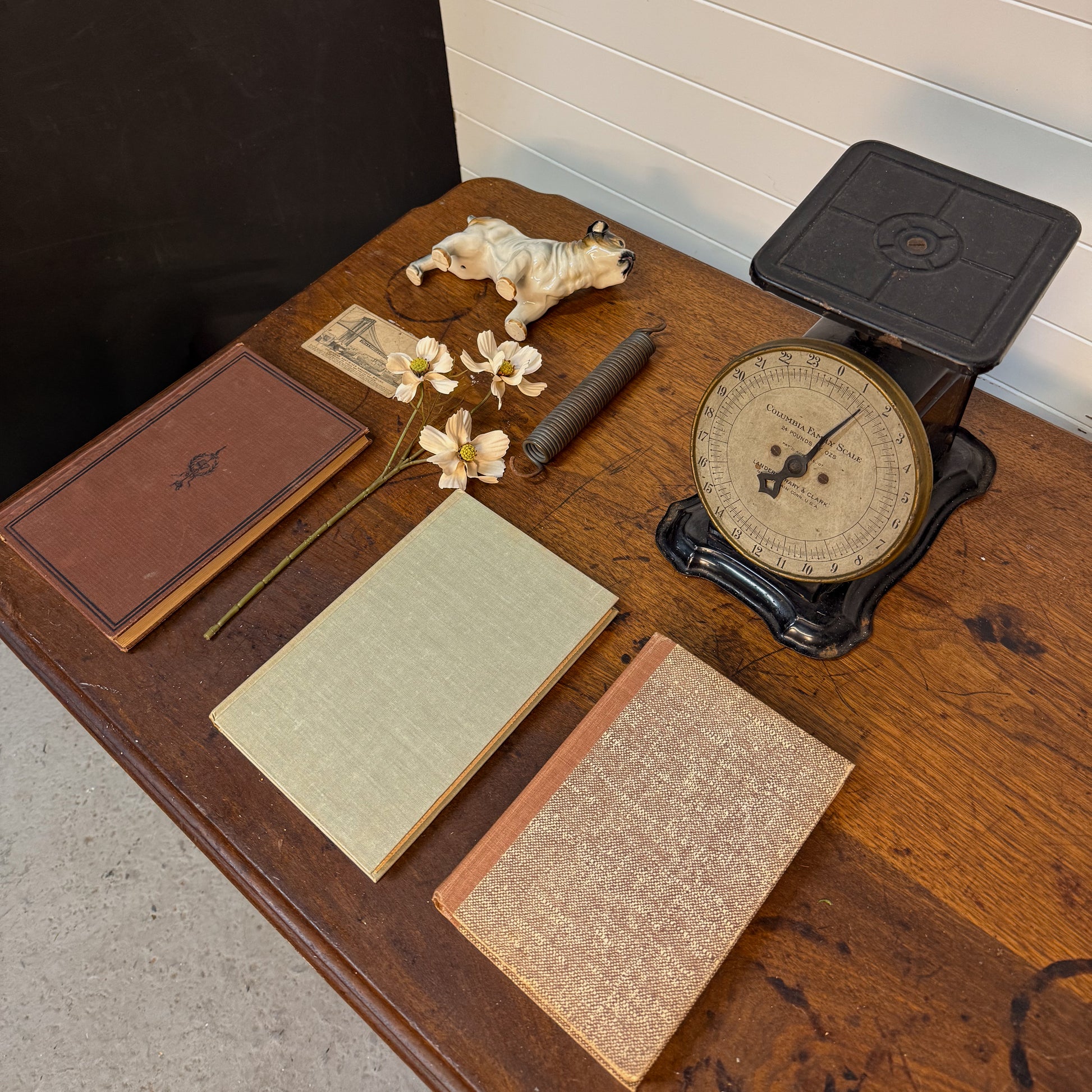 Vintage scale, books, and small figurine on a wooden surface.