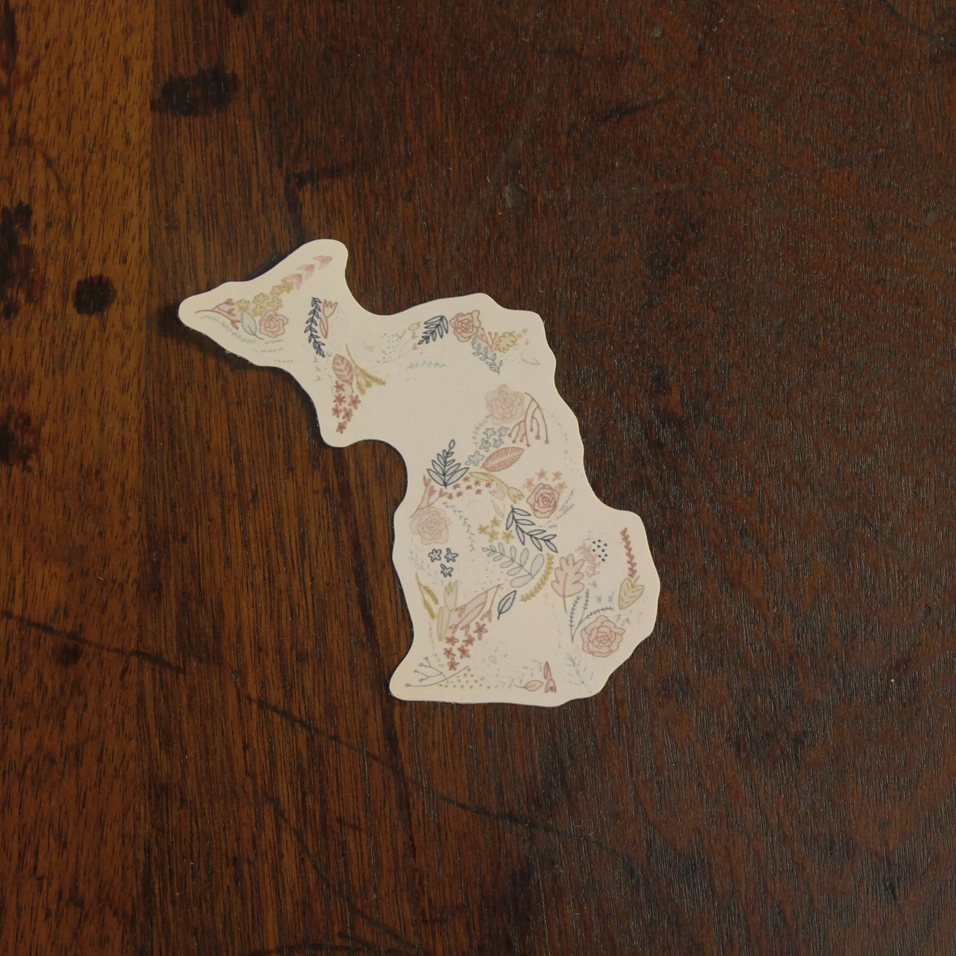 Decorative paper cutout of a floral design on a wooden surface