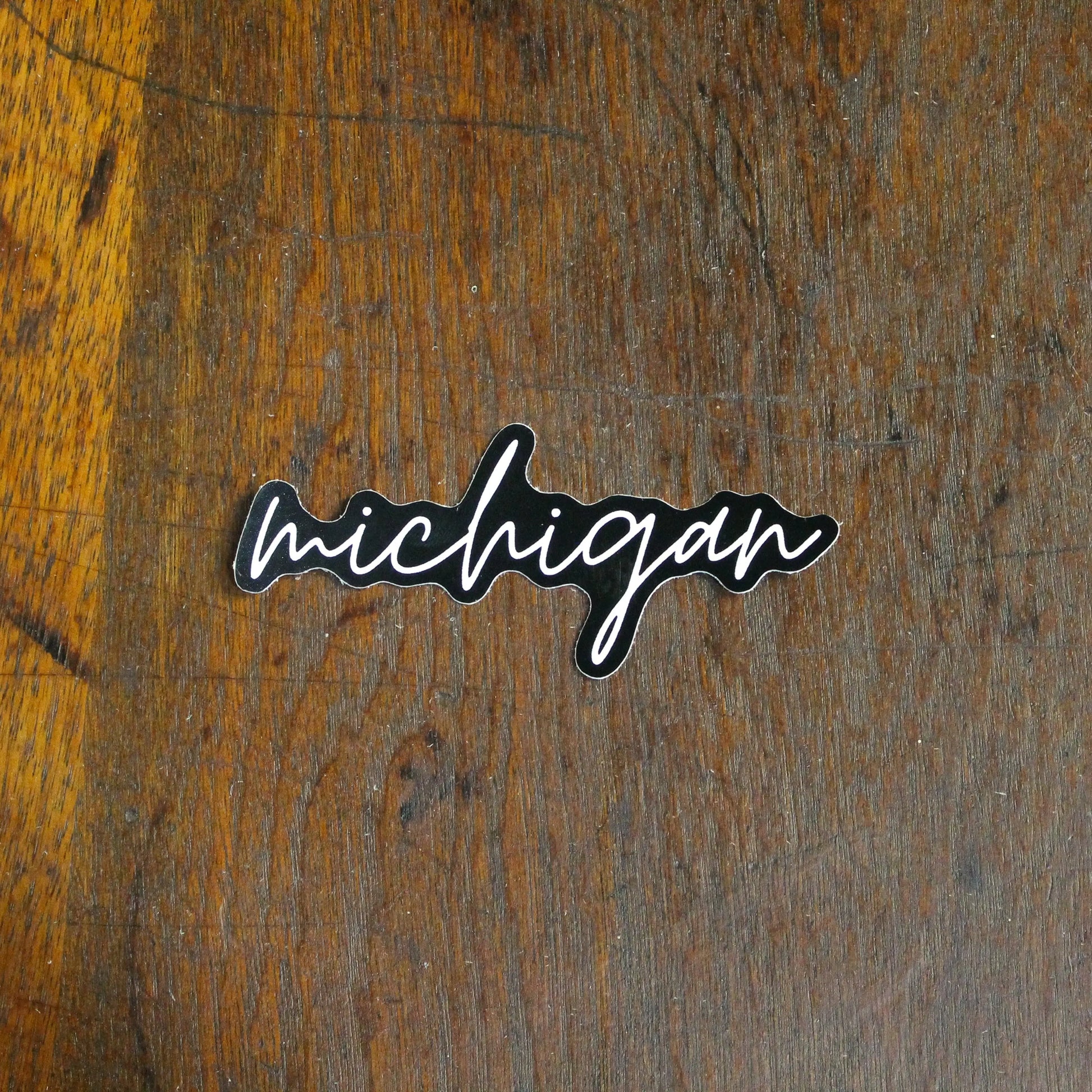 Text 'michigan' sticker on a wooden background