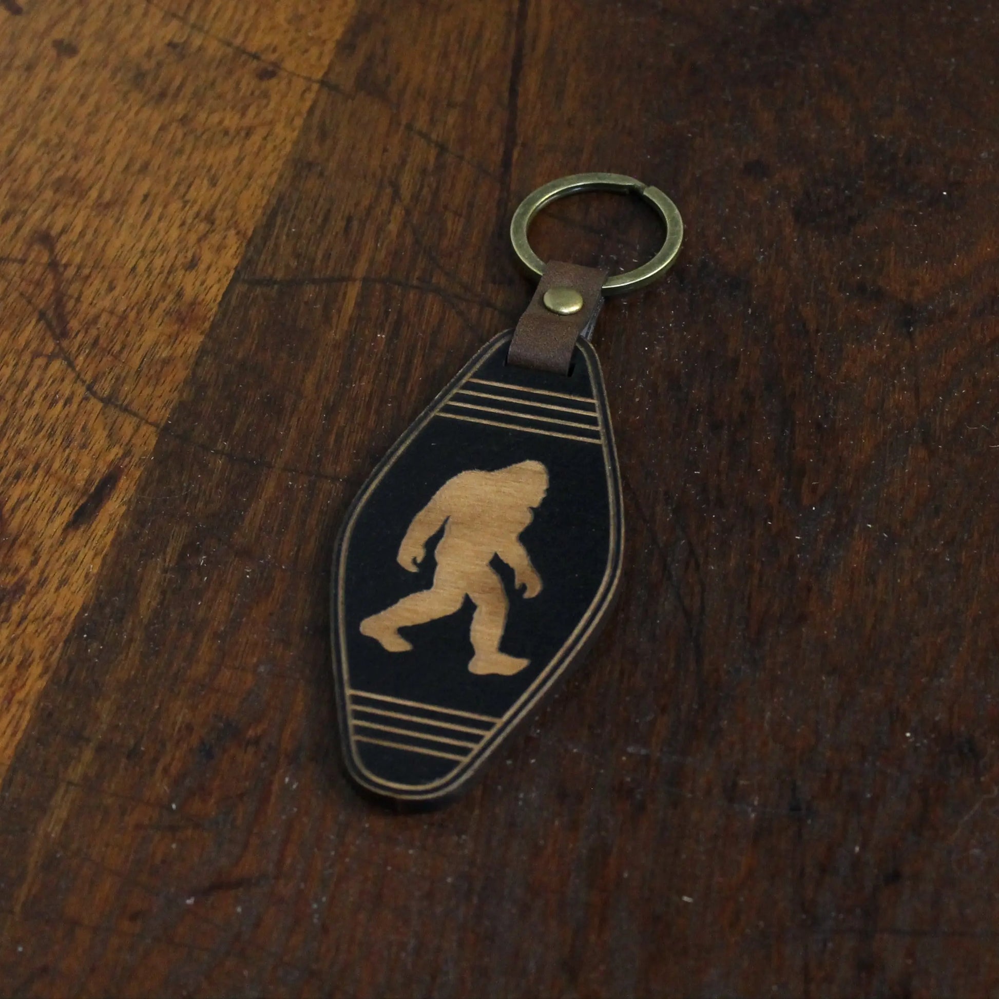 Keychain with Bigfoot design on a wooden surface
