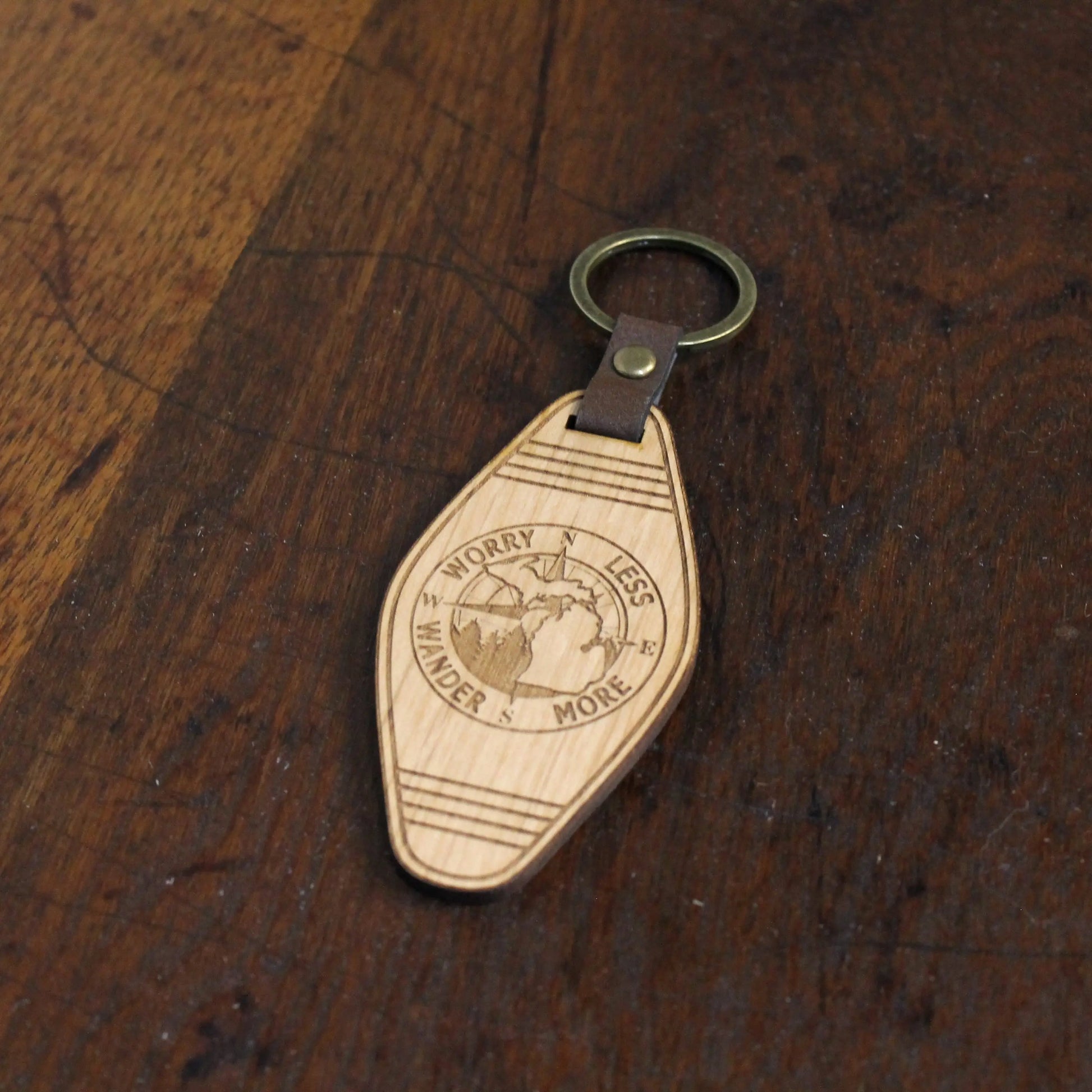 Wooden keychain with engraved design on a wooden surface