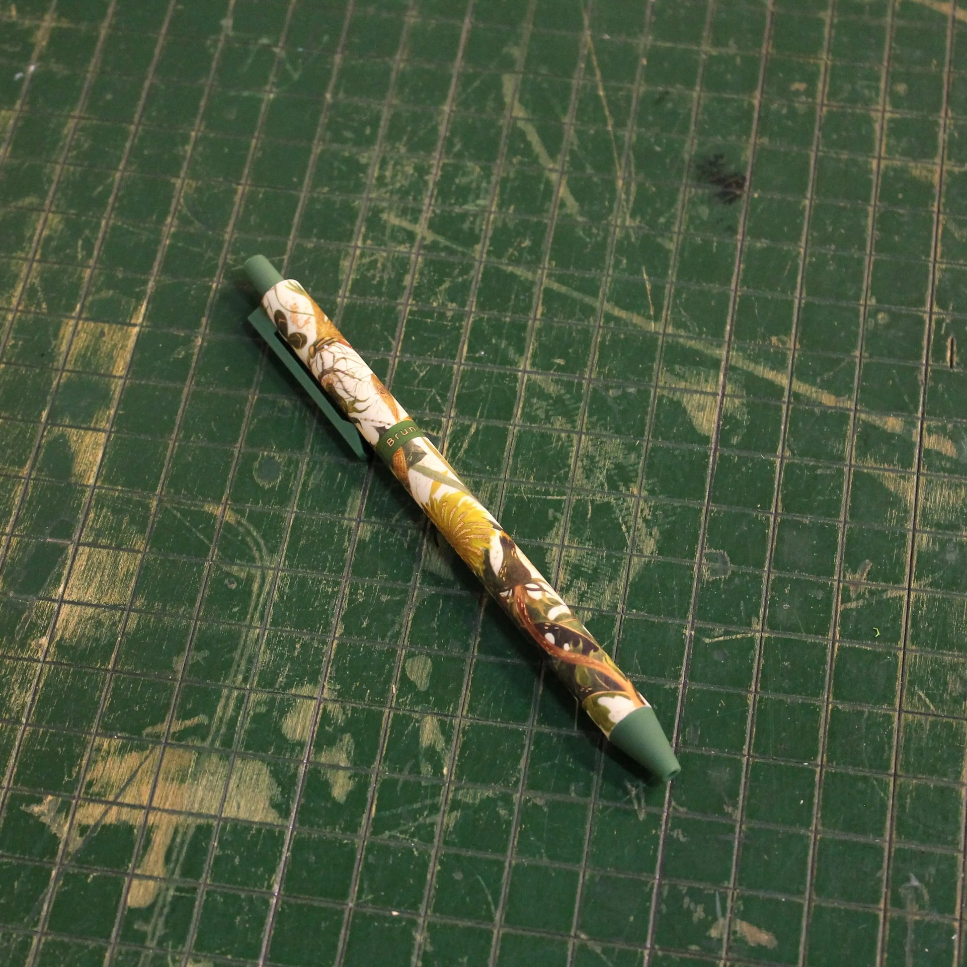 Decorative pen on a green grid background