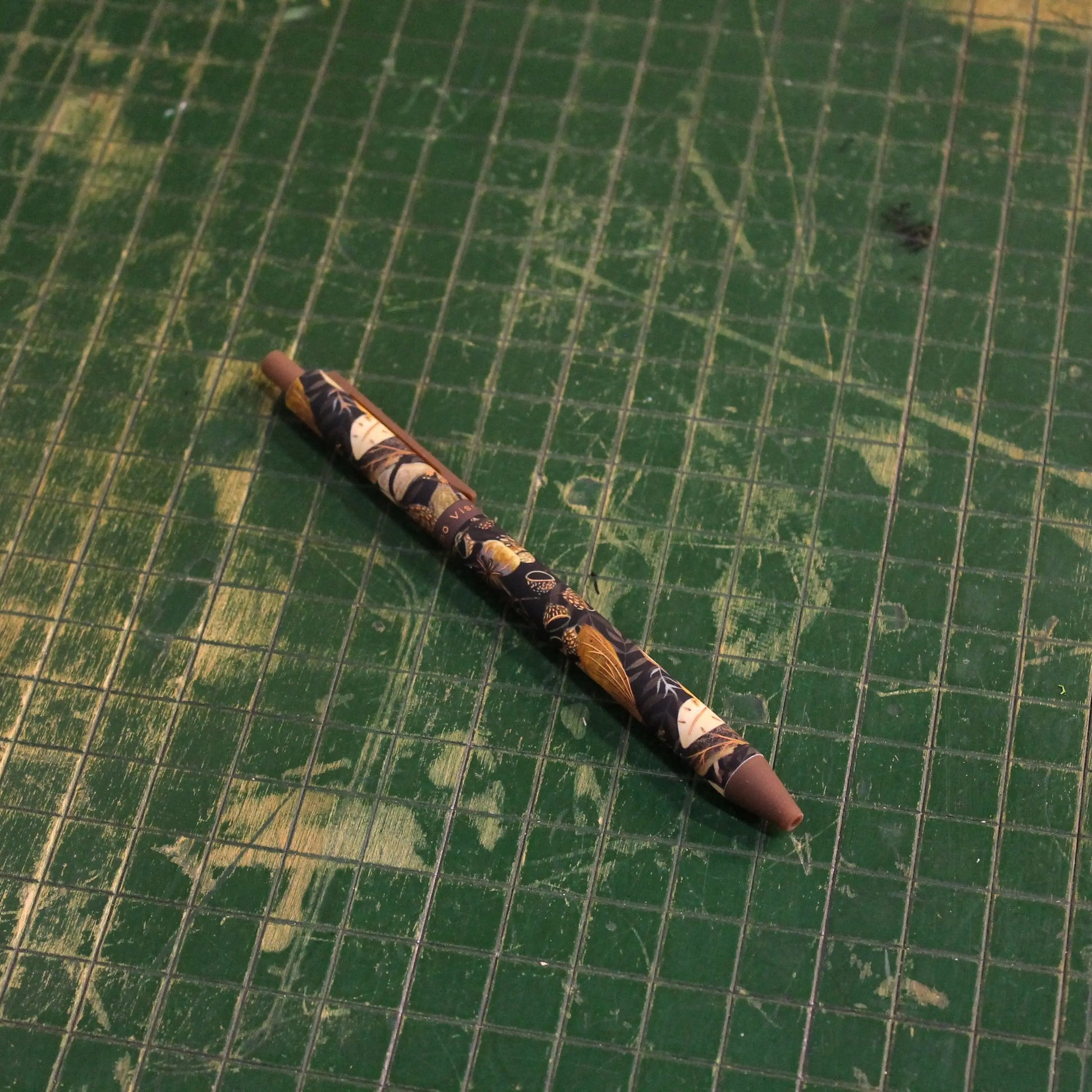 Decorative pen on a green grid background