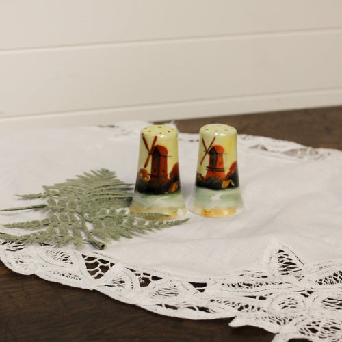 Salt and pepper shakers with mill design on a lace doily