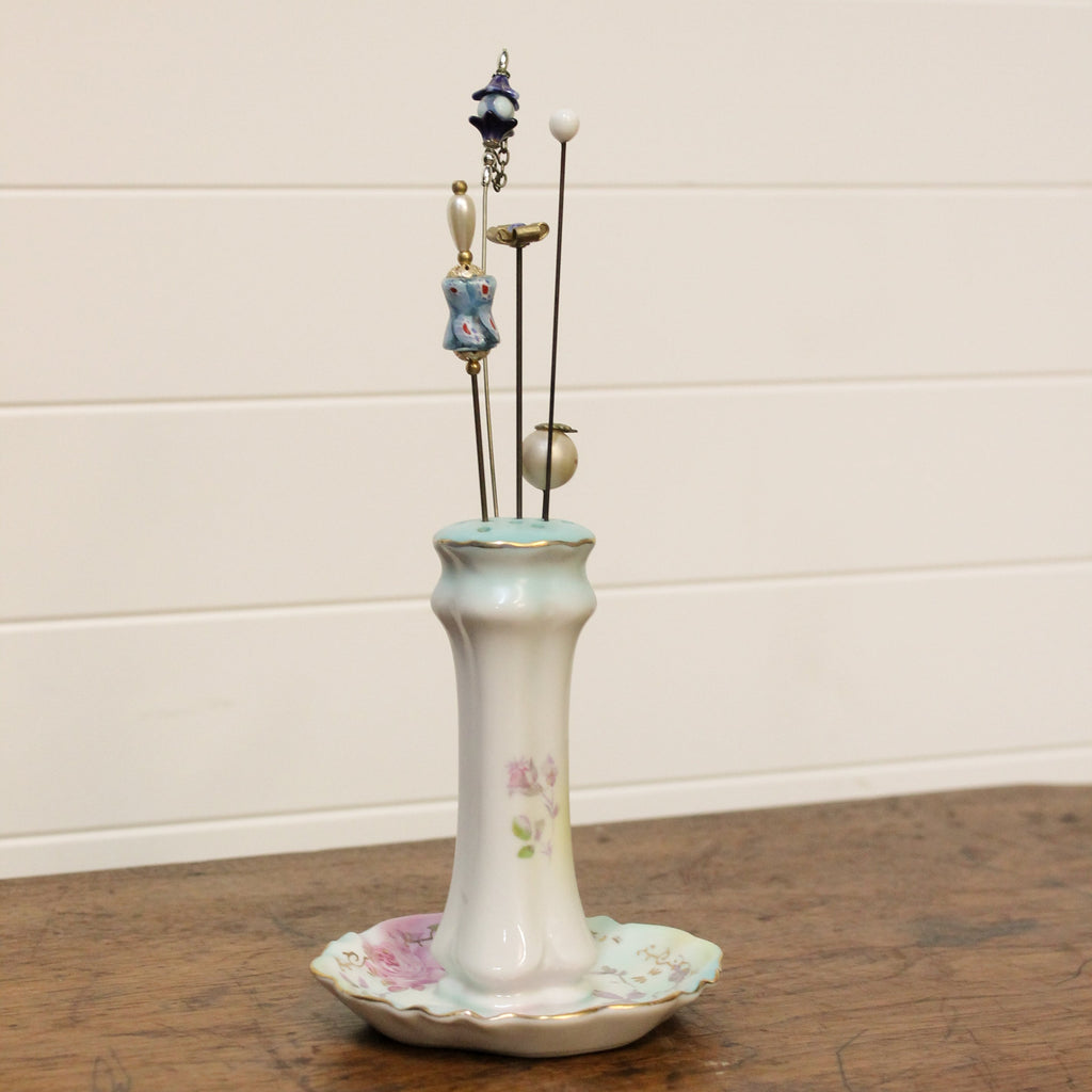 Decorative ceramic holder with small figurines on a wooden surface